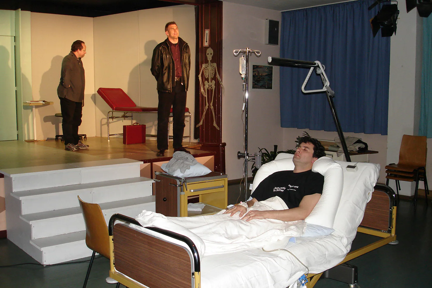Bühnenbild mit Krankenbett und erhöhter Spielfläche